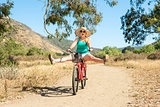 Young blond female riding a bike on a dirt trail