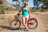 Young blond female smiling with a beach cruiser bike on a ride outdoors