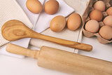 Overhead view of eggs, towels and kitchen tools on table