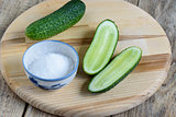 Fresh cucumbers and salt on a cutting board