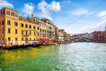 Venice, Italy. Gondolas on Grand Channel. Panorama view at Rialto Bridge. Piers