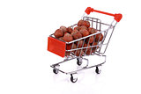 Nuts in miniature shopping cart isolated on white background