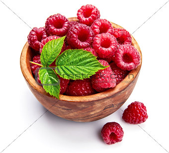 Fresh raspberry in wooden dish with green