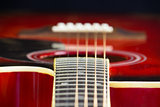 Acoustic red guitar lies on the table, dark background mode with a copy of the hands of space, playing on the classic Spanish, close-up of fretboard and strings, instrument deck, Wallpaper
