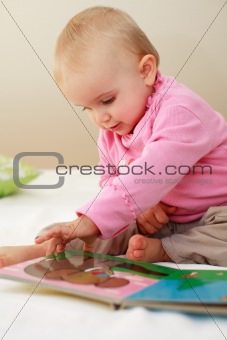 Small cute baby reading a book