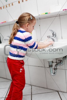 Small girl washing her hands