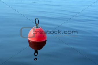 red-orange buoy in the blue water