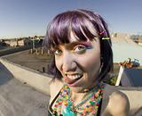 Cute young woman on a roof sticking out her tongue
