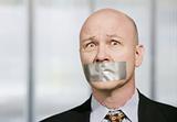 Worried businessman muzzled with duct tape