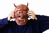 Person Holding Up A Devil Mask
