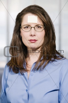 Businesswoman with a blank note on her forehead