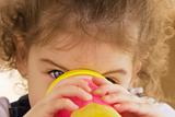 Little girl drinking from a pink cup