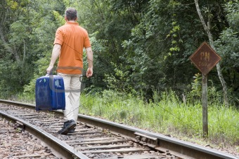 Man with suitcase on railway