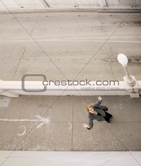 Woman on a sidewalk with her hands in the air