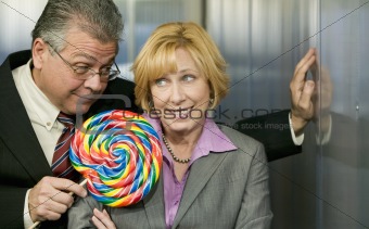 Man in office offers coworker a lollipop