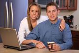 young couple on a kitchen with laptop