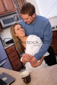 young couple on a kitchen with laptop