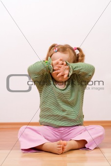 Little girl hiding behind her hands - copyspace