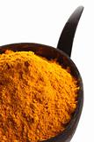 spices - pile of bright yellow ground TURMERIC in coconut bowl
