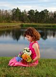 Pretty girl with flowers at the lake