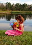 Pretty girl with flowers at the lake