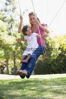 Mother and daughter on garden swing