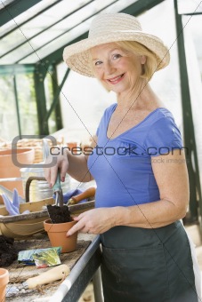 Senior woman working in greenhouse