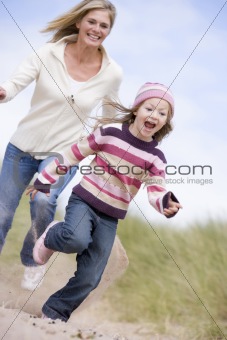 Mother chasing daughter through sand dunes