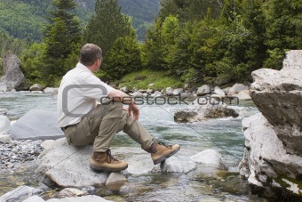 Hiker sitting at a mountain creek
