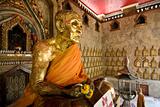 Statue of a sitting buddha inside  a buddhist temple in Bangkok, Thailand