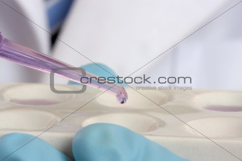Scientist, chemist  with pipet and spotting plate