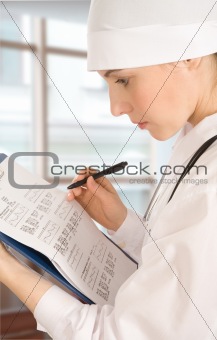 The doctor in a white jacket does records in documents