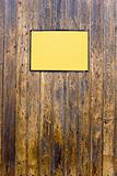 Grungy wood texture with a yellow sign for background