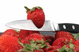 strawberries with metal knife with white background