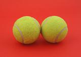 two tennis balls on red