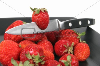 strawberries on Black Plate over White with knife