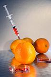 Syringe injecting liquid into an orange