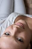 young glamour woman in white laying on her back and looking upside down