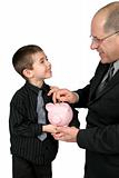 Man puting Money in Boys Piggy Bank
