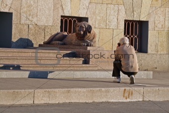Hiker take a photograph granite sculpture lion