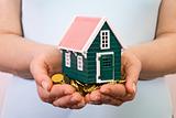 House on a pile of money in woman hands