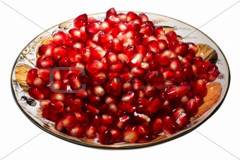 Pomegranate grains on a plate.  Isolated on white.