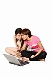 two young girls discusing on a laptop