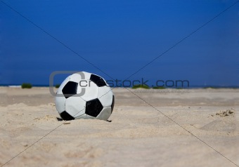 Soccer ball on sandy beach