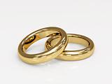 Two 3d gold wedding ring, laying on a glossy surface