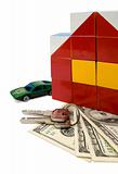 Toy house and a car over a bunch of dollars, isolated with clipping path