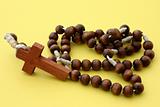wooden rosary on yellow