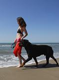 woman and rottweiler on the beach