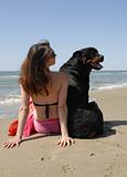 woman on the beach withe her rottweiler