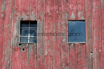 Two window on the side of a old barn